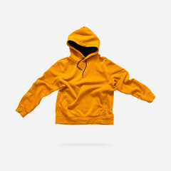 Flying fashionable orange hoodie isolated on gray background. Stylish men women unisex jacket, cotton sweater, hoody, hood, autumn clothes. Sweatshirt mockup. creative Hoodie template for design