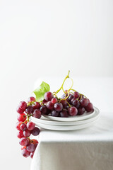 Red grape on the white linen tablecloth