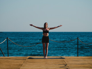 Fototapeta na wymiar young woman doing yoga on the beach