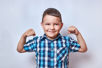 The boy raised his arms and tensed his biceps. Sports and active recreation.