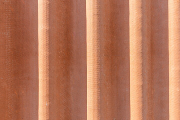 Corrugated red asbestos roof.A fragment of a roof background.
