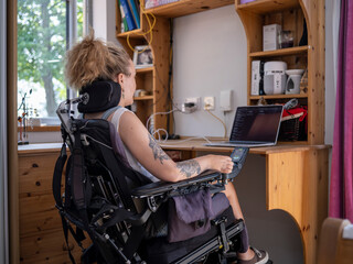 Woman in electric wheelchair working on laptop