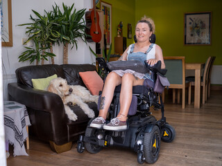 Woman in electric wheelchair with dog in living room