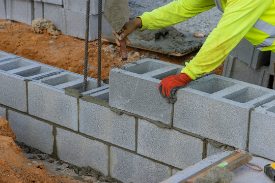 An aerated concrete block wall is being mounted by a mason man as part of the mounting process in construction site