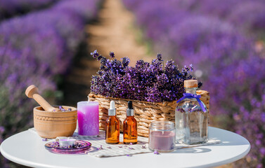 Dropper bottle with lavender cosmetic oil or hydrolate against lavender flowers field as background...