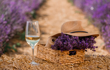 Glass of white wine in a lavender field in Provance. Violet flowers on the background