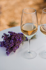 Two Glasses of white wine in a lavender field in Provance. Violet flowers on the background