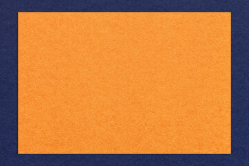 Texture of craft orange color paper background with navy blue border, macro. Structure of vintage dense kraft cardboard