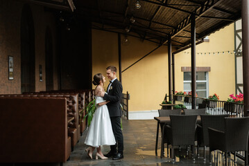 Naklejka na ściany i meble young couple bride and groom in a white short dress