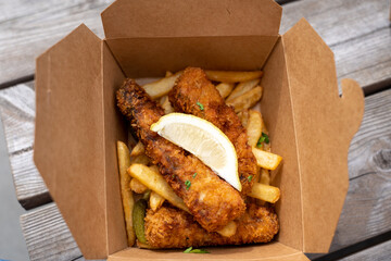 Fish and chips in a cardboard box, great colors , golden brown filet 