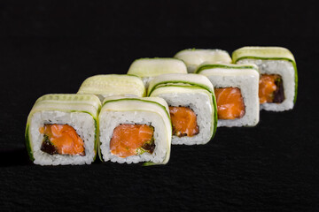 Roll with cucumber, rice, nori, salmon, green tobiko caviar