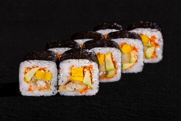 Rolls with nori, rice, avocado, omelette, eel, tobiko caviar