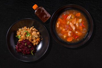 A plate of soup and a plate of rice with chicken