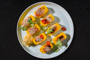 Plate with rolls with omelette, sesame seeds, ginger, parsley