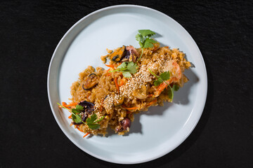 Rice with octopus, squid, mussels, sesame seeds, shrimps, carrots