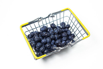 Blueberries on a white background. A small shopping basket full of blueberries. Useful and tasty berry.