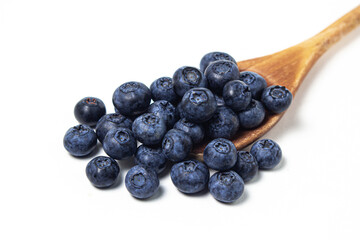 Blueberries on a white background. Wooden spoon full of blueberries. Useful and tasty berry.