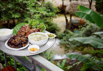 Home cooked family meal with signature dishes boiled escargots, bamboo shoot soup, roasted duck of...