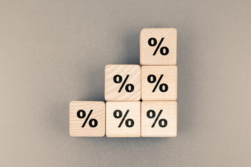 Percent icon on stack of wood cubes, percentage increase step by step, progressive percent...