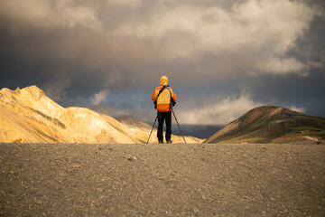 Lonely tourist photographer by himself taking tripod photograph of icelandic mountain landscape