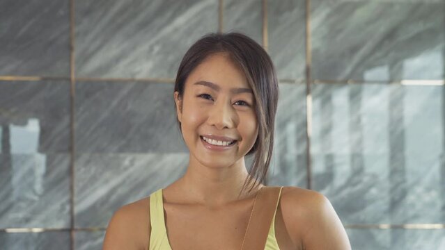 Portrait of smiling fit healthy Asian woman, person, doing exercise, working out, and training in gym or fitness center in sport and recreation concept. Lifestyle activity.