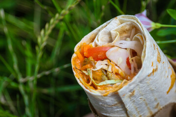 Shawarma Asian dish in man's hand at daytime