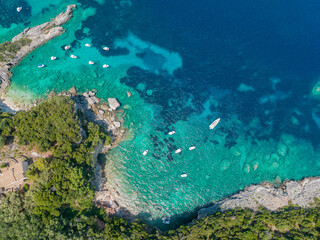 Fototapeta na wymiar Aerial view of Klimatia Beach, close to Limni beach on the island of Corfu. Coastline. Transparent and crystalline water, moored boats and bathers. Vacation. Greece 