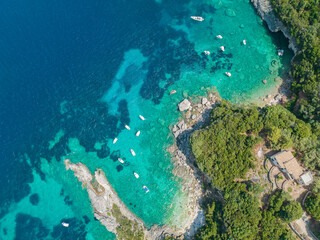 Aerial view of Klimatia Beach, close to Limni beach on the island of Corfu. Coastline. Transparent and crystalline water, moored boats and bathers. Vacation. Greece
