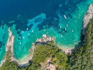 Naklejka na ściany i meble Aerial view of Klimatia Beach, close to Limni beach on the island of Corfu. Coastline. Transparent and crystalline water, moored boats and bathers. Vacation. Greece 