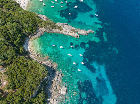 Aerial view of Klimatia Beach, close to Limni beach on the island of Corfu. Coastline. Transparent and crystalline water, moored boats and bathers. Vacation. Greece © Naeblys