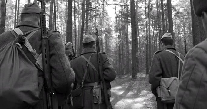 4K Squad Men Dressed As World War II Russian Soviet Red Army Soldiers Marching Through Spring Forest In Sunny day. Soldier Of WWII WW2 Times. Black And White Colors.