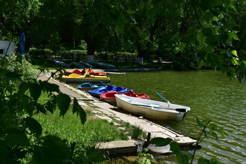 boats and catamarans at the pier on the city lake on a summer day
