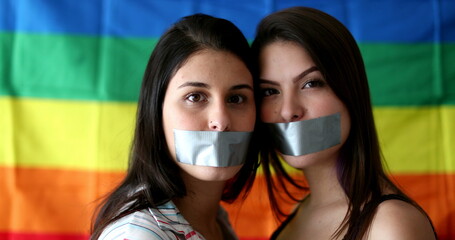 Two lesbian girlfriends with mouth duct taped unable to speak. LGBT censorship concept
