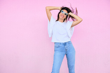 happy young woman posing in a fun way with heart shaped sunglasses 