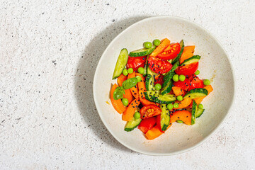 Summer vegetables salad in a modern bowl. Bright vegan food, trendy hard light, dark shadow