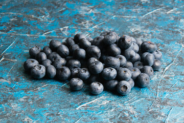 Blueberry berry on table close up macro, blue concrete background with copy space