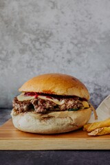 Hamburger frites sur planche a découpé fond neutre