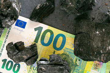 Coal heating in Europe.Charcoal and one hundred euro bills on the EU flag.Coal industry in the...