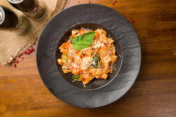 Pasta fettuccine with shrimps in tomato sauce on wooden table