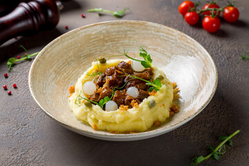 Beef cheeks with mashed potatoes on brown table