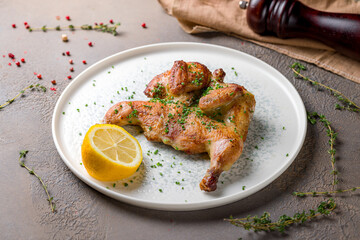 fried chicken tobacco with sliced green onion and lemon on plate