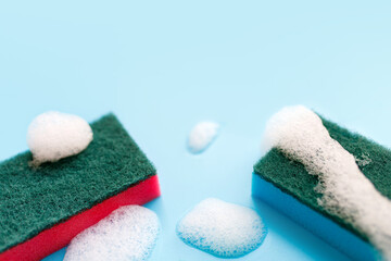 Multicolored sponges for cleaning on a blue background. Space for text.