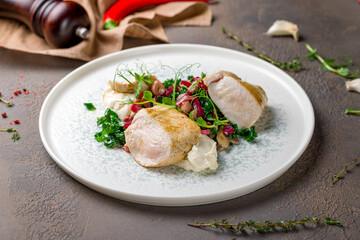 Sliced Grilled chicken Breasts with garnish on plate on brown table