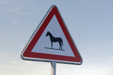 attention horses sign warns of unattended animals on the roadway specifically for horses, in the...