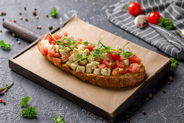 bruschetta with tomatoes and cheese on the board on grey table
