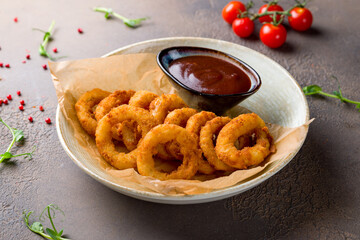 Onion rings in batter with bbq sauce on plate