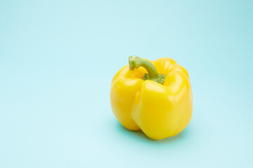 Close up of yellow bell pepper isolated on blue background.