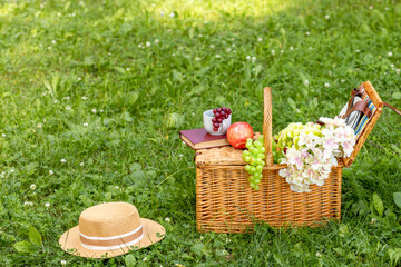 Fototapeta na wymiar Lunch in the park on the green grass. Summer sunny day and picnic basket. Copy space