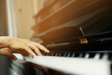 close up of hand people man musician playing piano keyboard with selective focus keys. can be used...