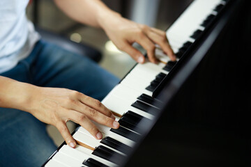 Obraz premium close up of hand people man musician playing piano keyboard with selective focus keys. can be used as a background.